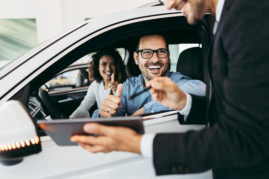 Dealer Explaining vehicle Features To Happy Customers